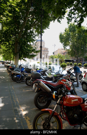 Les motocycles et scooters garé à l'ombre des arbres dans la Piazza dell'Esquilino, Rome, Italie Banque D'Images