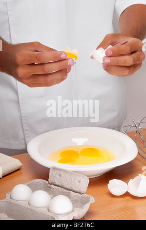 Homme casser des œufs dans un bol Banque D'Images