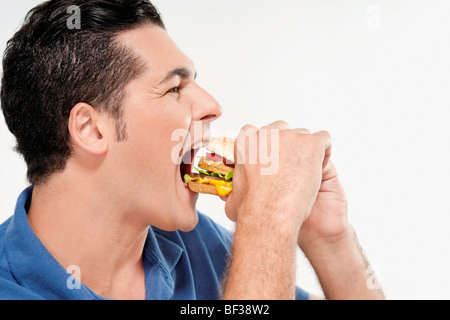 Man eating a hamburger Banque D'Images