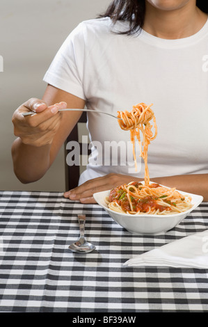 Mid section view of a woman eating spaghetti Banque D'Images