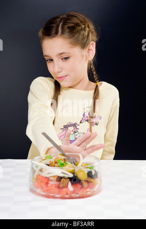 Close-up of a Girl poussant un bol de salade à l'écart Banque D'Images