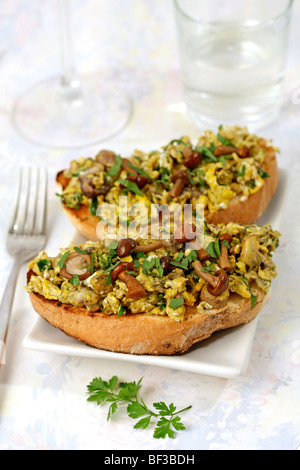 Oeufs brouillés et des champignons sur toast Recette disponible. Banque D'Images