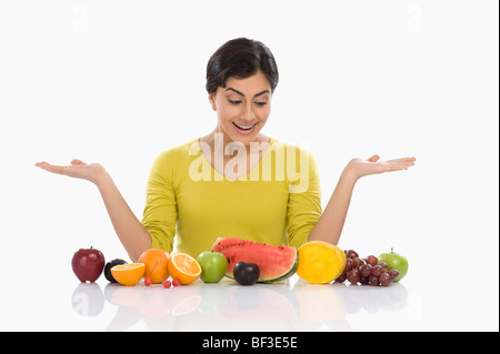 Femme regardant un assortiment de fruits frais et des gestes Banque D'Images