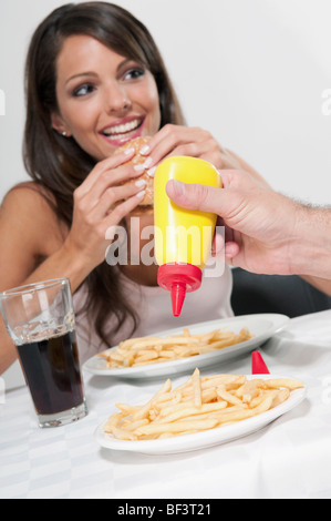 Woman eating a hamburger Banque D'Images