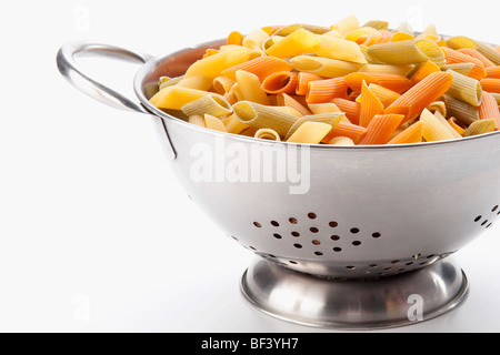 Pâtes rigatoni multicolores dans une passoire Banque D'Images