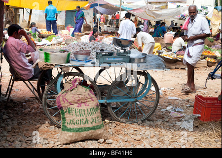 L'homme indien vente de l'ail d'un garrot sur le jour du marché, Puttaparthi, Andhra Pradesh, Inde Banque D'Images