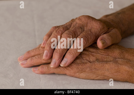 Personnes âgées les mains pliées sur fond blanc Banque D'Images