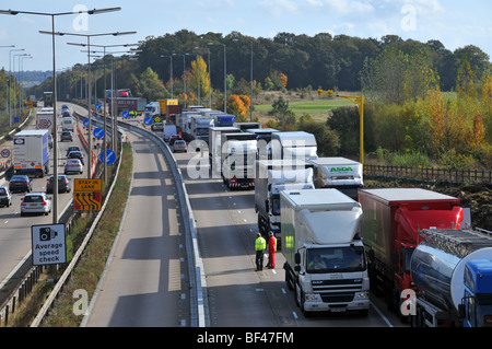 Lointain tournant autour de la police et d'autres camions engorgée le trafic sur autoroute M25 section travaux routiers après la fermeture en raison d'un accident Banque D'Images