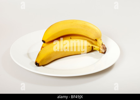 Petite botte de bananes on White Plate Banque D'Images