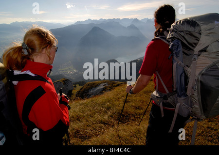 Les randonneurs, femme et homme avec des sacs à dos et bâtons de marche sur le sommet du Mt. Heidachstellwand, 2192m, avec vue sur l'Auberge Val Banque D'Images