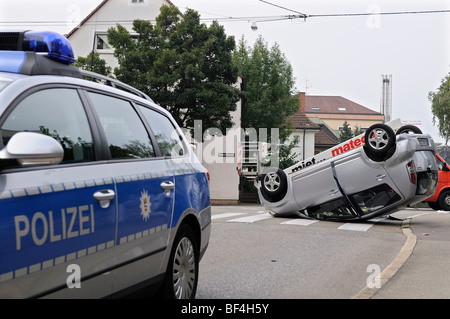 Daihatsu voiture ayant renversé dans un accident de la circulation, couché sur le toit, voiture de patrouille à l'avant-plan, Stuttgart, Baden-Wuertt Banque D'Images