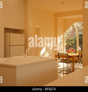 Lavabo dans l'unité de l'île blanche blanc moderne dans une salle à manger cuisine ensoleillée Banque D'Images