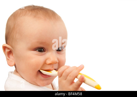 Mettre bébé cuillère dans sa bouche. Isolées. Banque D'Images