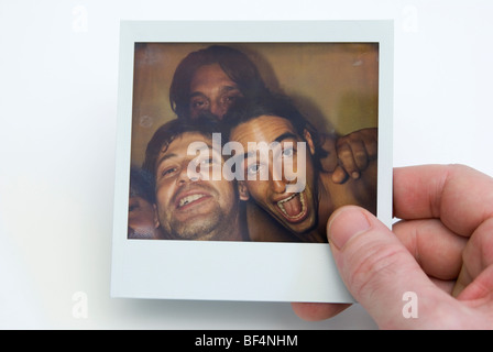 Main tenant avec vos amis photo Polaroid Banque D'Images