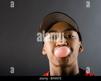 Mixed Race baseball player blowing bubble gum avec Banque D'Images