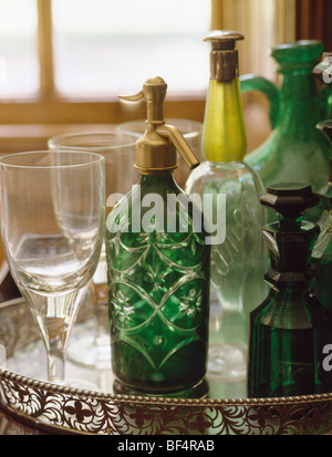 Close-up of antique en verre vert soda-siphon et bouteilles sur le plateau métallique Banque D'Images