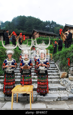 Les jeunes femmes Miao Miao en costume traditionnel accueille les touristes avec du vin, comté de Leishan, Kaili Ville, province du Guizhou, Chine Banque D'Images