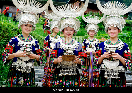 Les jeunes femmes Miao Miao en costume traditionnel accueille les touristes avec du vin, comté de Leishan, Kaili Ville, province du Guizhou, Chine Banque D'Images