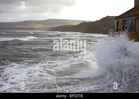 Les vagues se briser sur un bâtiment à Robin Hoods Bay Banque D'Images