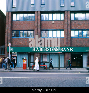 Habibsons Bank sur Whitechapel High Street et des gens qui attendent à l'arrêt de bus à l'extérieur de Londres Angleterre Royaume-uni KATHY DEWITT Banque D'Images