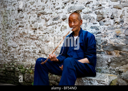 Une minorité Dong man smoking pipe, Qiandongnan Préfecture autonome Miao et Dong, province de Guizhou, Chine Banque D'Images