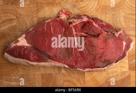 Tranche brute de chump surlonge de longhorn organiques sur une vache irlandaise bloc bouchers en bois Banque D'Images