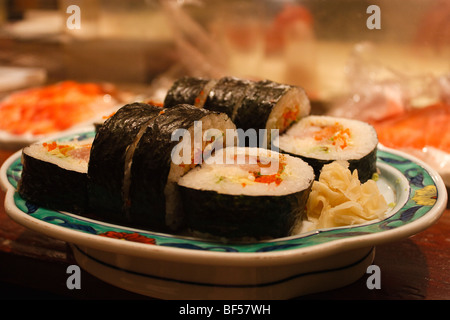Maison délicieux sushi roll futomaki avec saumon, thon, installations pour barbecue, la peau du saumon et oeufs de poisson volant recouvert d'algues sur l'extérieur. Banque D'Images