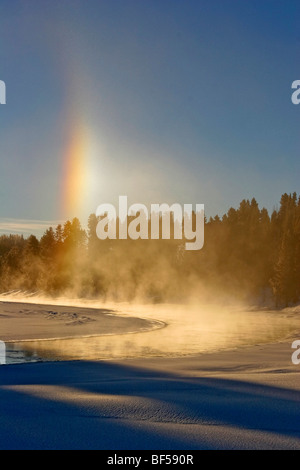 Arc-en-ciel Sun dog (causée par la vapeur qui se reflète sur le soleil) sur la rivière Yellowstone en hiver, Yellowstone NP. Banque D'Images