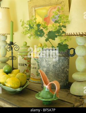 Close-up of orange vert +pot sur table avec lampes et bol de citrons Banque D'Images