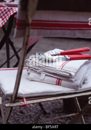 Close-up de coutellerie à poignée rouge et rouge tranchant , plateau-serviettes sur chaise en métal Banque D'Images