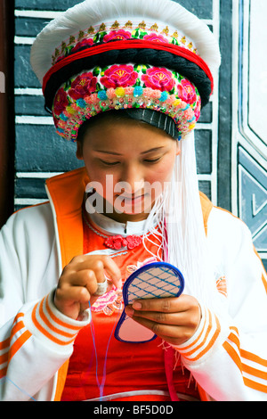 Minorité ethnique Bai jeune femme semelle couture, Lijiang, Province du Yunan, Chine Banque D'Images