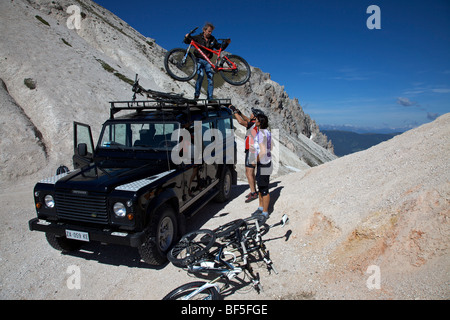 Les coureurs de vélo de montagne Vélo de chargement d'un landrover à la Kreuzjoch gorge de montagne, fodara vedla dans bassin, parco naturale fanes Banque D'Images