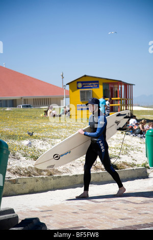 Surfer carrying board - le long de la promenade de Muizenberg - Cape Town Banque D'Images