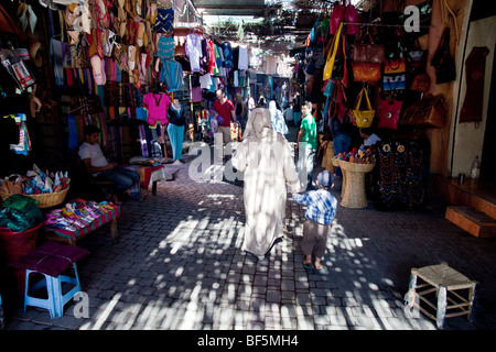 Une femme en hijab marche dernières souk dans la médina de Marrakech, Maroc Banque D'Images