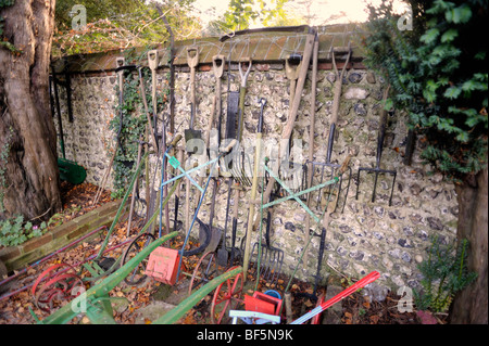 Une rangée de vieux outils de jardin suspendu à un mur Banque D'Images