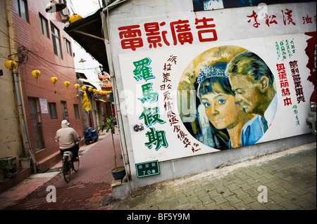 Un homme sur un vélo passer une annonce pour une Audrey Hepburn film à Taipei, Taiwan. Banque D'Images