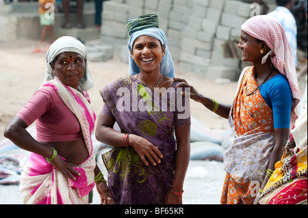 Les femmes indiennes qui travaillent sur les routes de rire et plaisanter ensemble. Puttaparthi, Andhra Pradesh, Inde Banque D'Images