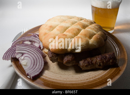 Cevapcici. Fast food bosniaque. Rouleaux de viande grillée dans pain somun tout simplement servi avec oignon et souvent accompagnés de la bière. Banque D'Images