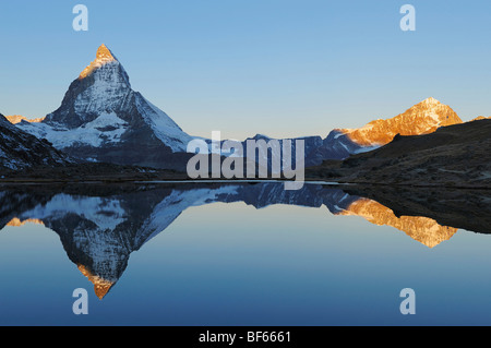 Matterhorn au lever du soleil en hiver avec reflet dans l', Riffelsee Zermatt, Valais, Suisse, Europe Banque D'Images