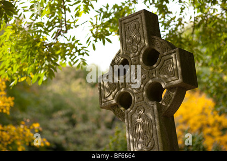 Vieille pierre tombale dans un cimetière avec des couleurs automnales dans les arbres Banque D'Images