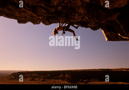 Une femme rock climber est suspendu d'un surplomb dans le désert du centre de l'État de Washington. Banque D'Images
