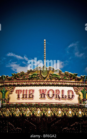 Panneau sur le haut du carrousel traditionnel - le monde, vu contre un ciel bleu Banque D'Images