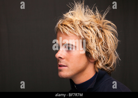 Studio, UK, Grande-Bretagne. Tête portrait d'un jeune homme à l'écoute Banque D'Images