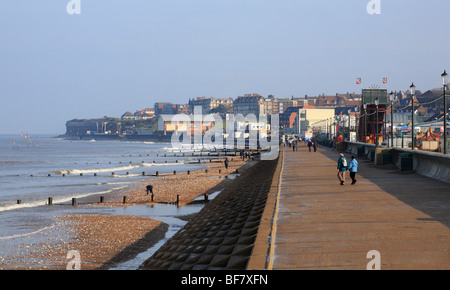 Les gens qui marchent sur la promenade au soleil d'automne à Hunstanton. Banque D'Images