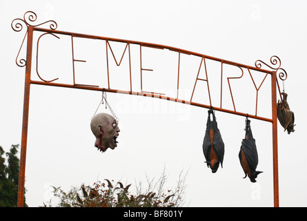 La tête d'horreur factice et handwerk suspendu d'un cimetière signe en tant que partie d'un affichage de l'Halloween. Banque D'Images