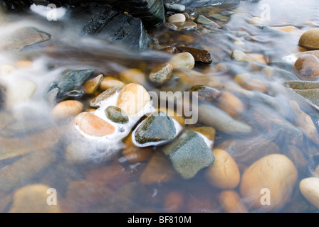 Fonctionnement de l'eau fraîche sur les pierres dans un ruisseau à l'océan Banque D'Images