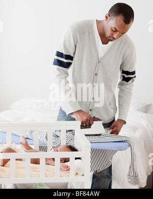 Homme africain planche shirt près de bébé en crèche Banque D'Images