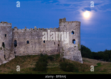 La Lune se levant derrière Château de Carew à côté de la rivière à Carew Carew, Pembrokeshire, Pays de Galles Banque D'Images