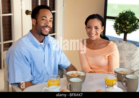 Une happy African American man and woman couple dans la trentaine assis à l'extérieur ayant un petit-déjeuner sain Banque D'Images