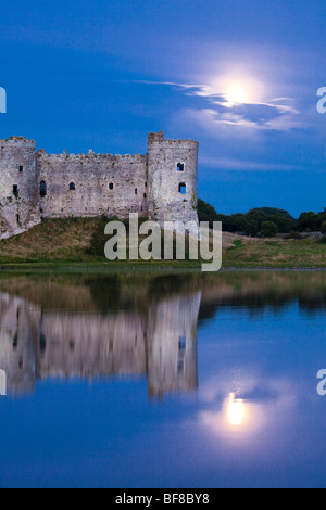 La Lune se levant derrière Château de Carew à côté de la rivière à Carew Carew, Pembrokeshire, Pays de Galles Banque D'Images